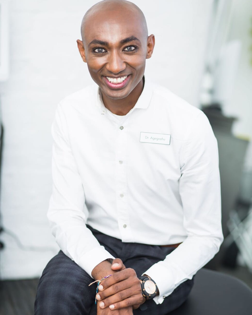 Dr. Daniel Agegnehu, chiropractor at Alem Integrated Health, seated and smiling